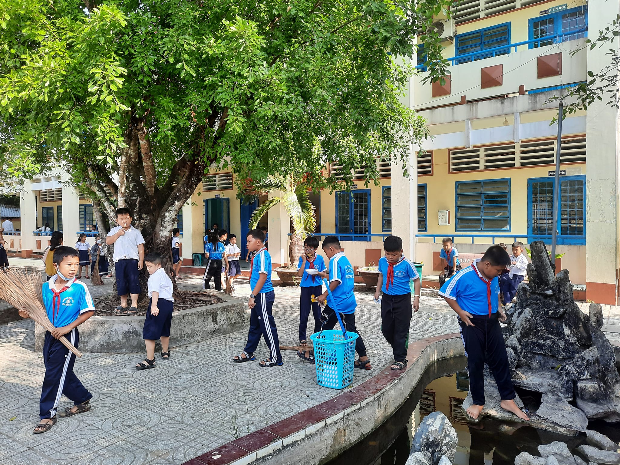 Các em học sinh vệ sinh khuôn viên trường
